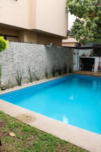 a blue swimming pool in front of a building at Departamentos Perfectamente ubicados con alberca in Ciudad Madero