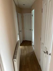 an empty hallway with a staircase and a room with doors at Phoenix caravan hire, Trecco bay in Porthcawl