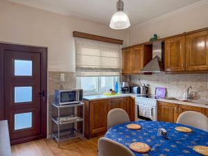 a kitchen with wooden cabinets and a table with a microwave at Elitee Superior Mountain Residence in Vitina