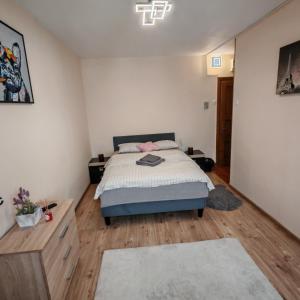 a bedroom with a bed and a wooden floor at Magic Apartments 2 in Miercurea-Ciuc