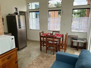 a kitchen and dining room with a table and a refrigerator at Casa BLUE Praça 102 in Carrancas +9 photos