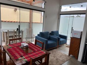 a living room with a blue couch and a table at Casa BLUE Praça 102 in Carrancas