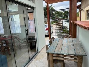 a patio with a wooden table and a glass door at Casa BLUE Praça 102 in Carrancas