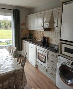 a kitchen with white cabinets and a table and a table and a tableablish at Old Killarney in Killarney