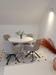 a dining room with a white table and chairs at Popas 26 in Nădlac