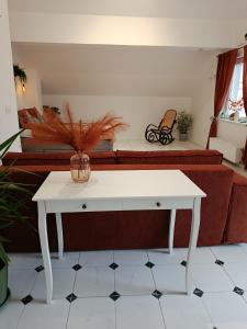 a white table in a living room with a couch at Popas 26 in Nădlac