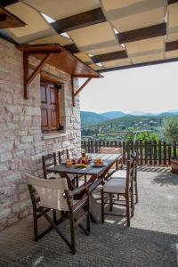 a wooden table and chairs on a patio at Μικρό σαλέ. in Pournára