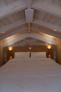 a bedroom with a large white bed with two pillows at Μικρό σαλέ. in Pournára