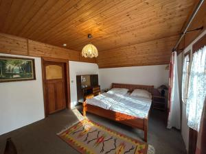 a bedroom with a bed and a wooden ceiling at Hostinec Na hrázi in Hamr na Jezeře