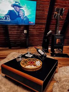 a table with a pizza and a tv in a room at Retiro Empíreo in Nova Petrópolis
