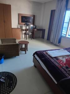 a bedroom with a bed and a couch and a table at Hotel ratna priya pvt ltd in Biratnagar