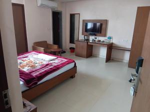 a bedroom with a bed and a desk and a television at Hotel ratna priya pvt ltd in Biratnagar