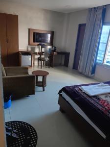 a hotel room with a bed and a couch and a table at Hotel ratna priya pvt ltd in Biratnagar