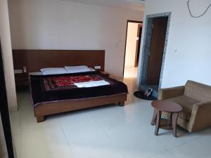 a bedroom with a bed and a chair and a table at Hotel ratna priya pvt ltd in Biratnagar