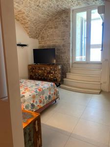 a bedroom with a bed and a tv and a window at Virgin Mare in Giovinazzo