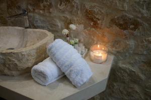 a bathroom with a sink with towels and a candle at Seascape Apartment with Private Balcony in Faliraki in Faliraki