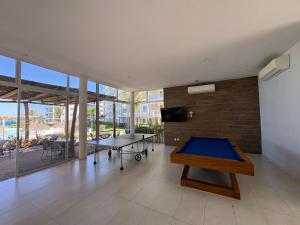 a room with two ping pong tables and a brick wall at Fantástico Depa en BLUU con Playa Artificial ! in Mazatlán