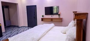 a bedroom with two beds and a flat screen tv at Pelican VVIP Villa in Wa