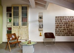 - un salon avec deux chaises et une table dans l'établissement B&B Sottotetto, à Reggio d'Émilie
