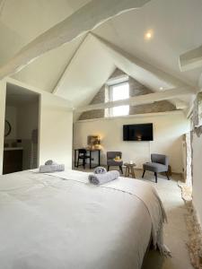a bedroom with a large white bed in a room at Mas de Méjas Chambre d'hôtes La Pierraille in Calvignac