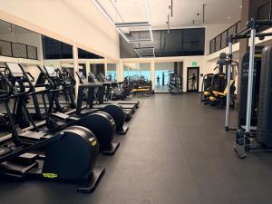 a gym with a row of treadmills and machines at District 225 in Miami