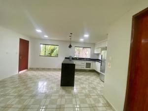 a large kitchen with white walls and a tile floor at Casa Centro do Rio in Rio de Janeiro