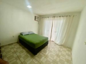 a bedroom with a green bed and a window at Casa Centro do Rio in Rio de Janeiro