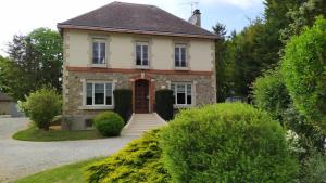 an old brick house with a red door at Le gÎte du mazagran in Leffincourt