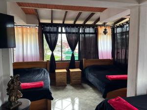 a bedroom with two beds and a window at Hotel Montañitas in Guatapé