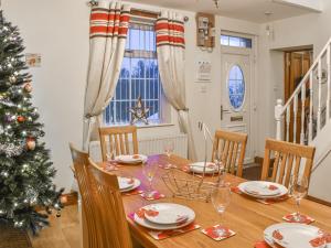 a dining room with a christmas tree and a table at Stonebank Cottage - Uk35686 in Hunwick
