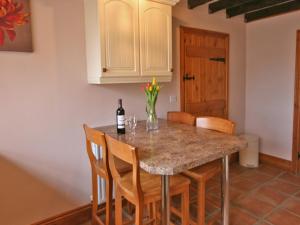 a kitchen with a table with a bottle of wine at Granary Cottage Whittingham in Whittingham