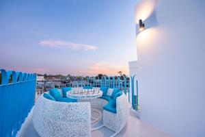 a balcony with blue and white chairs and a table at Blue Tierra Pool Villa Pattaya in Ban Hua Phrong +67 photos