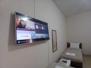 a flat screen tv hanging on a wall in a room at Pousada Imperatriz in Aparecida