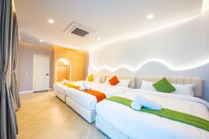 a bedroom with two beds with colorful pillows at Blue Tierra Pool Villa Pattaya in Ban Hua Phrong