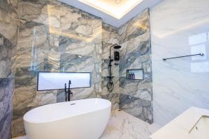 a bathroom with a white toilet and a stone wall at Blue Tierra Pool Villa Pattaya in Ban Hua Phrong