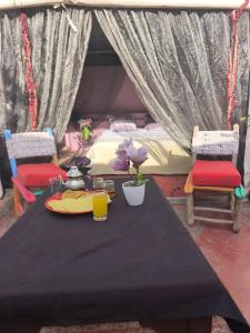 a table with a plate of food and two chairs at BKAN RIAD MARRAKECH in Marrakesh