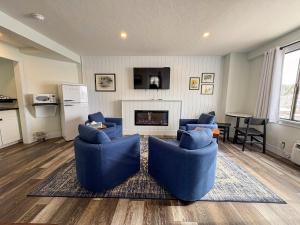 a living room with blue chairs and a fireplace at Hotel Nevada & Gambling Hall in Ely