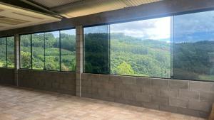 a room with a large window with a view of the mountains at Recanto Colina in Picada Cafe
