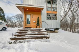 a house in the snow with a set of stairs at Couple’s Retreat Near UVM! Unique Studio w/ Deck in Burlington