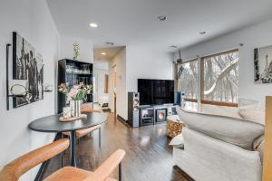 a living room with a couch and a table with flowers at Couple’s Retreat Near UVM! Unique Studio w/ Deck in Burlington