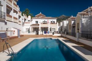 una piscina en una villa con una casa en Apartamentos Chimenea, en Nerja