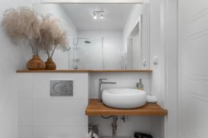 a bathroom with a sink and a mirror at AURA 77 Żoliborz in Warsaw