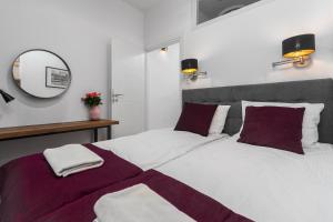 a bedroom with a large bed and a mirror at AURA 77 Żoliborz in Warsaw