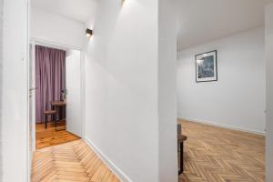 a hallway with white walls and a wooden floor at AURA 77 Żoliborz in Warsaw +92 photos