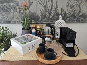 a table with a coffee maker and a box and cups at La suite a pochi passi dal mare in Trapani