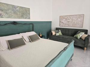 a bedroom with a large bed and a couch at La suite a pochi passi dal mare in Trapani +20 photos