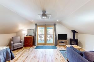 a living room with a couch and a tv at Half-Mile to Crystal Lake! Couples Retreat w/ Deck in Beulah