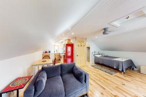 a living room with a blue couch and a bed at Half-Mile to Crystal Lake! Couples Retreat w/ Deck in Beulah