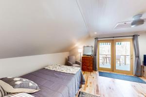a bedroom with a bed and a window at Half-Mile to Crystal Lake! Couples Retreat w/ Deck in Beulah