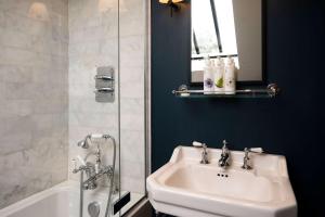 a bathroom with a sink and a bath tub at The Bottle & Glass Inn - Garden View - Room 1 in Henley on Thames